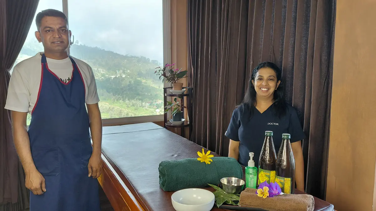 Two people beside a prepared treatment table.