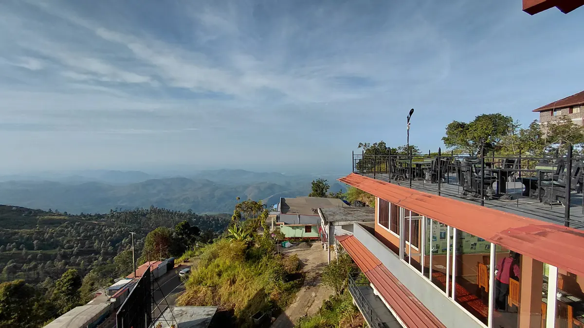 The Mist building and terrace against a hillside view.