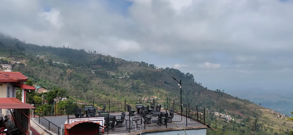 Terrace and hillside beneath a cloudy sky.